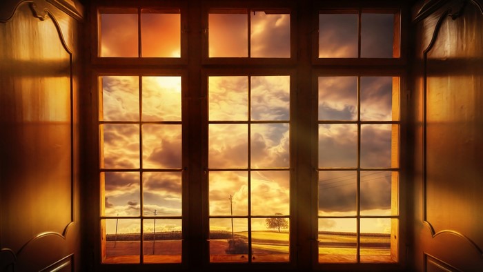 Window view of a sunset over a field