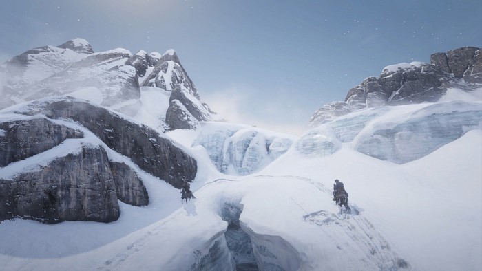 Two people on horseback in a snowy mountain landscape