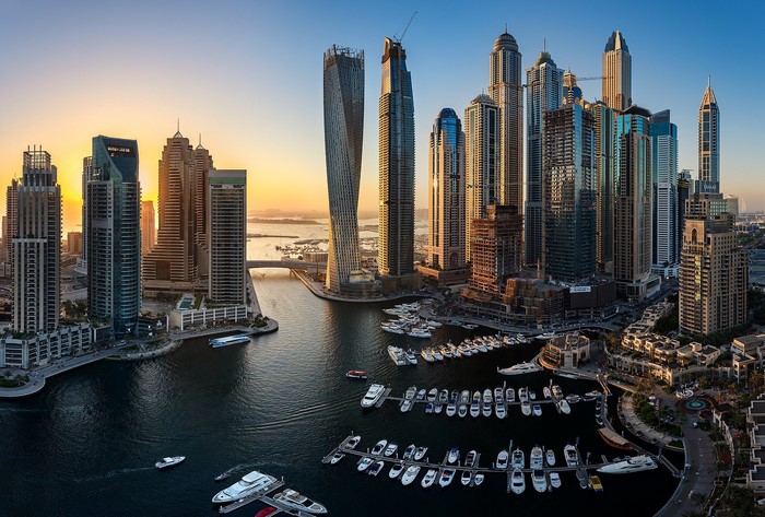Dubai Marina skyline with skyscrapers and boats at sunset