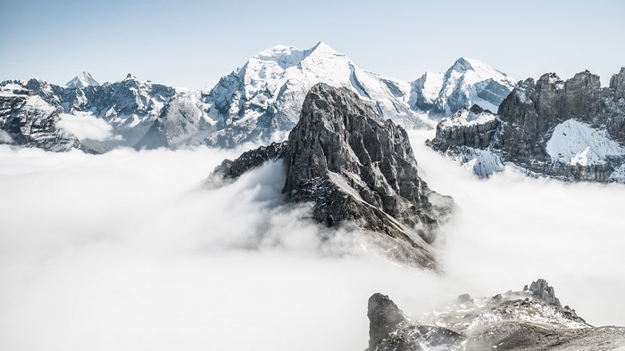 Snow-capped mountains above clouds in Bernese Alps