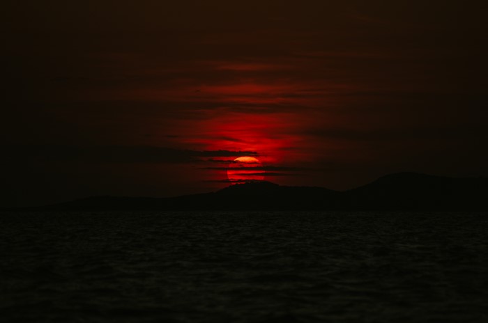 4K Red Sun Setting Over Sea and Mountains