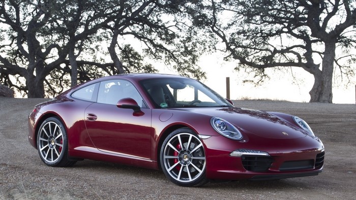 Red Porsche 911 parked outdoors with trees