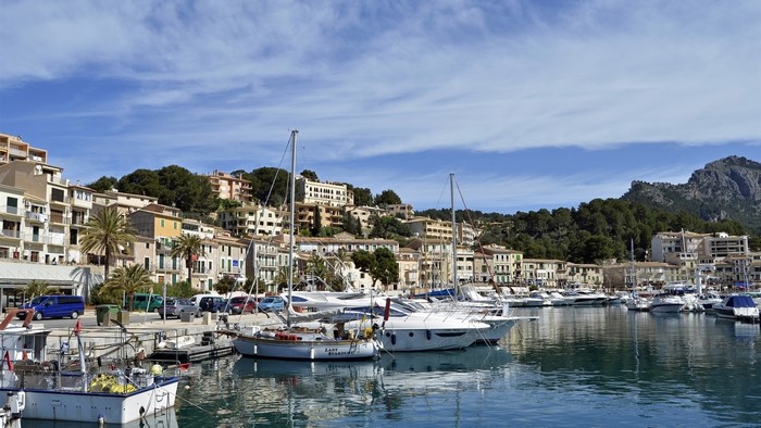 Boats docked in a harbor with buildings on a hillside
