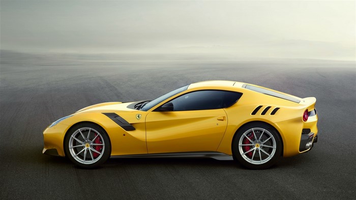 Yellow Ferrari sports car on asphalt