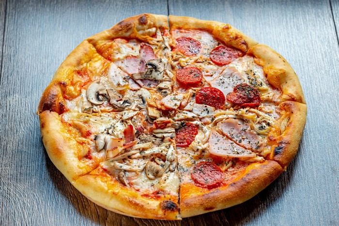 Pizza with salami, ham, and mushrooms