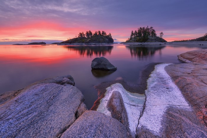 Lake islands at sunset with colorful sky and rocks