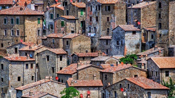 Old stone buildings with red tiled roofs in Sorano, Italy