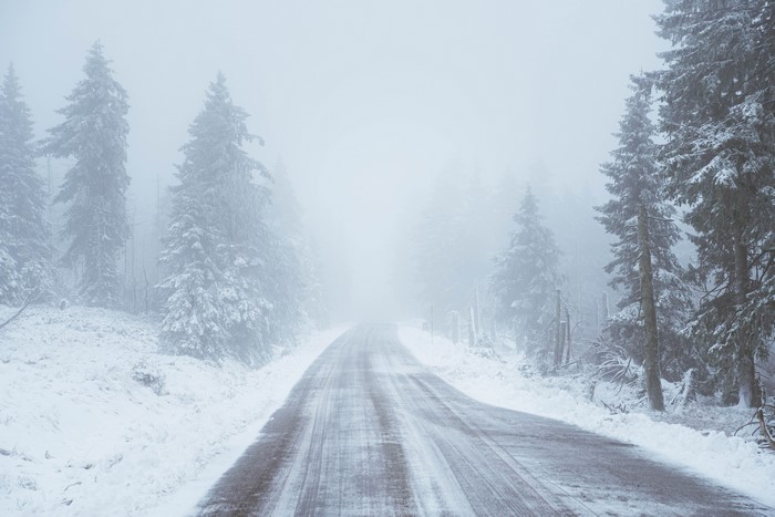 4K snow-covered road through winter forest