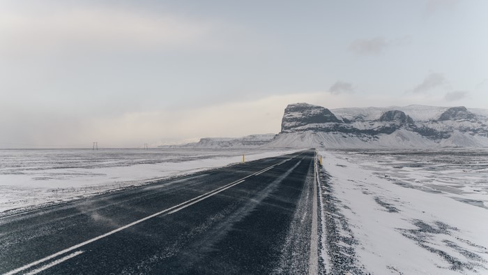 Road through a snowy landscape with mountains