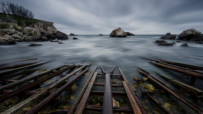 Long exposure of rocky coastline with old boat tracks