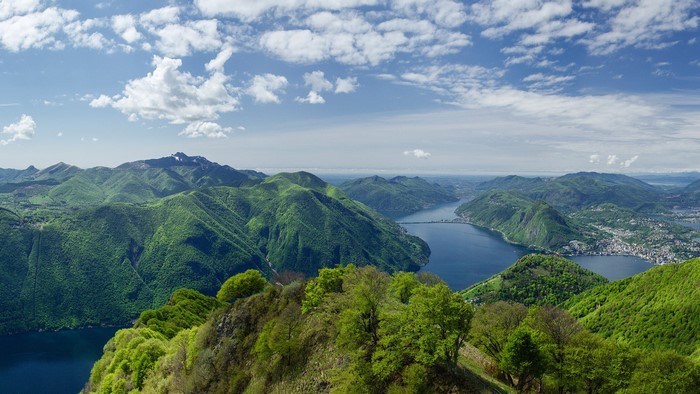Green mountains and lake landscape under a cloudy sky