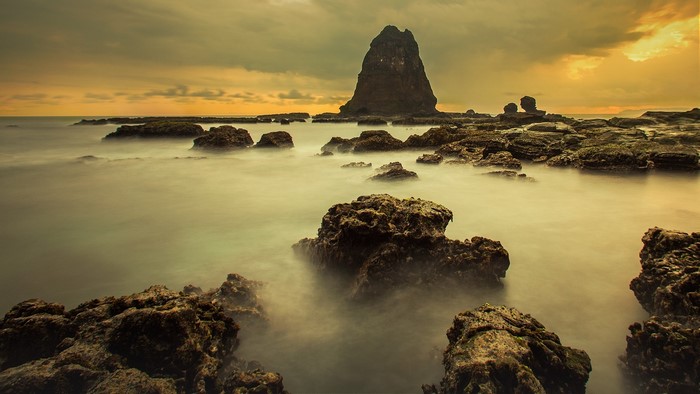Long exposure of Papuma Beach with rock formations at sunset