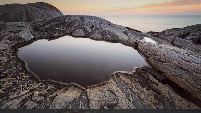 Rocky coastline with tide pool at sunset
