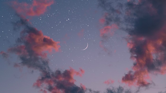 Crescent moon in a starry sky with pink clouds