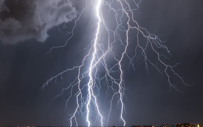 Lightning strikes over a city at night