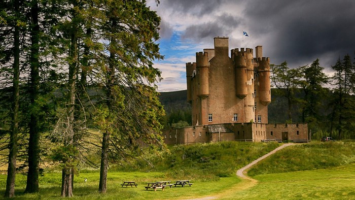 Castle in Scotland with trees and picnic tables