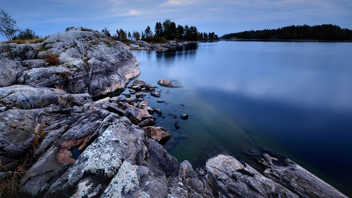 Rocky shore of Lake Ladoga with forest in the background