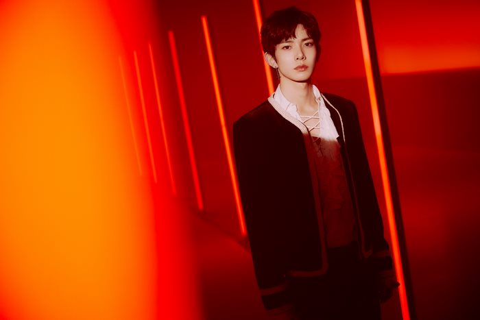 Heeseung from ENHYPEN in a dark studio