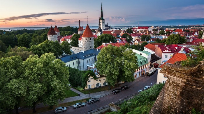 Tallinn Old Town skyline at sunset with trees and cars