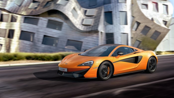 Orange McLaren 570S driving on asphalt road