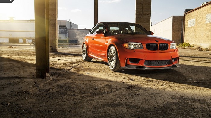Orange BMW 1 Series Coupe in an industrial area