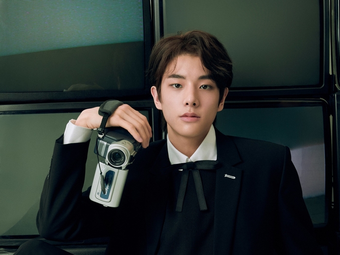 Jake from ENHYPEN holding a camcorder