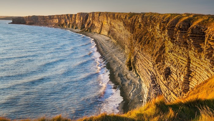 Coastal cliffs and sea at sunset in Wales, UK