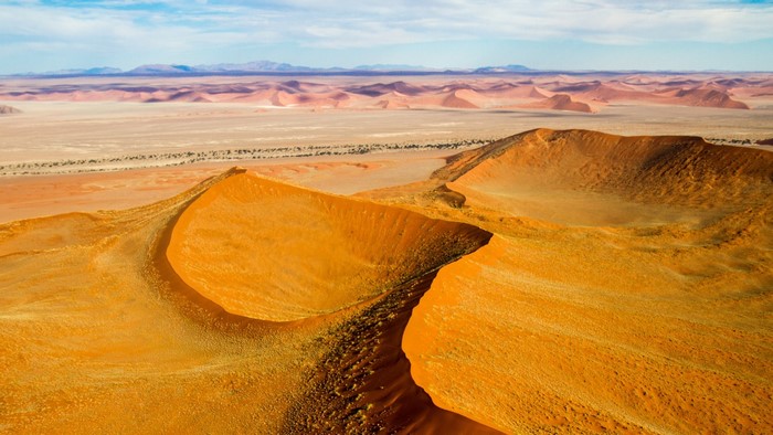 Namibian desert dunes with mountains in the distance
