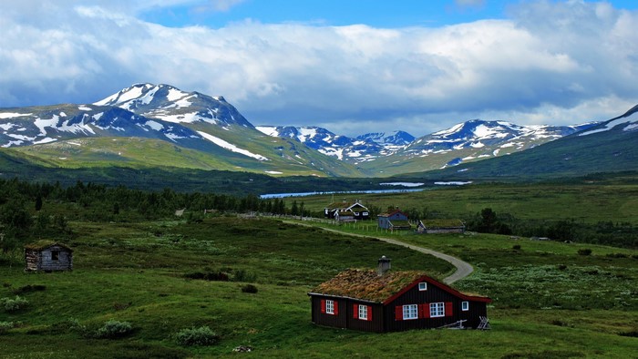 Houses in a mountain valley with snow-capped peaks