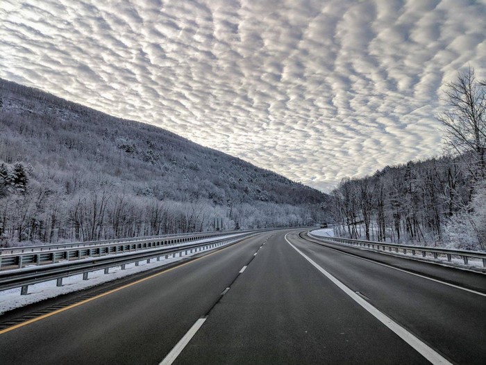 Winter highway through snow-covered mountains and forest