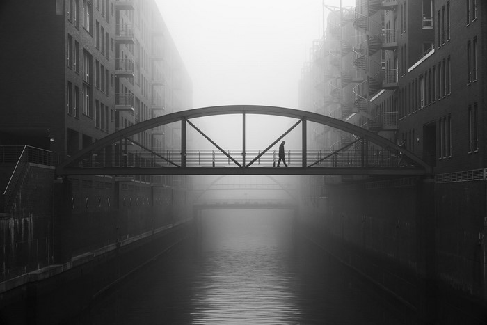 Man walking on a bridge over a canal in Hamburg, Germany