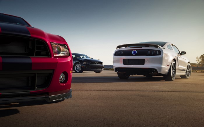 Three Ford Mustangs on a road