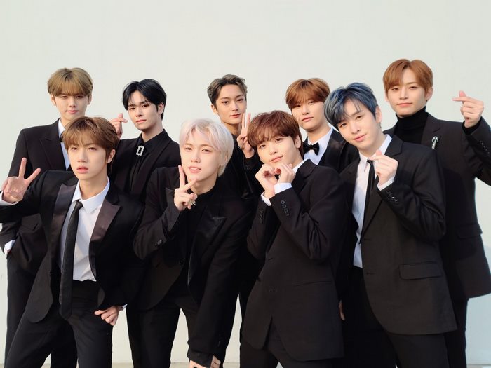 ENHYPEN members in black suits posing