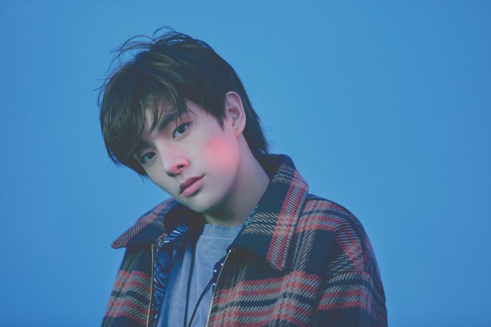 Jake from ENHYPEN posing against a blue background