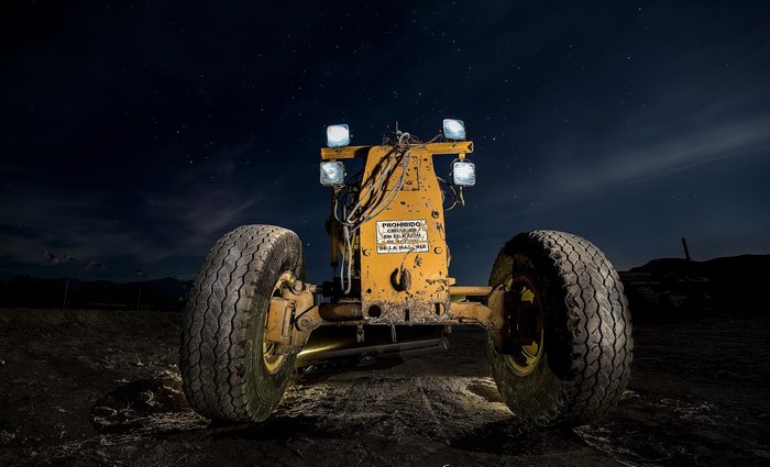 Yellow tractor at night with stars