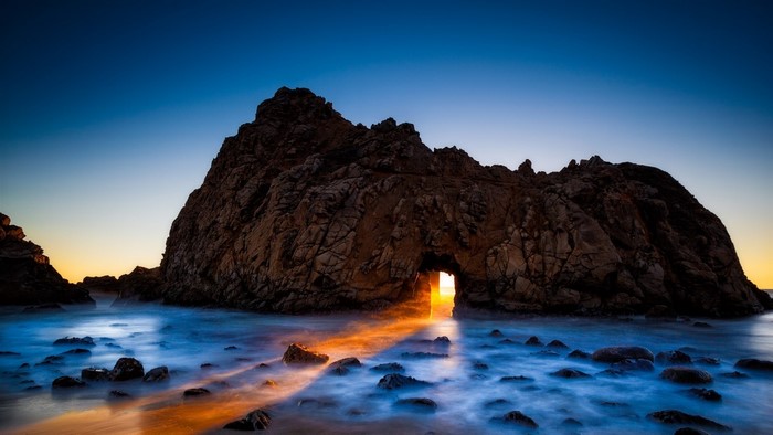 Rock Archway with Sunlight and Ocean Waves