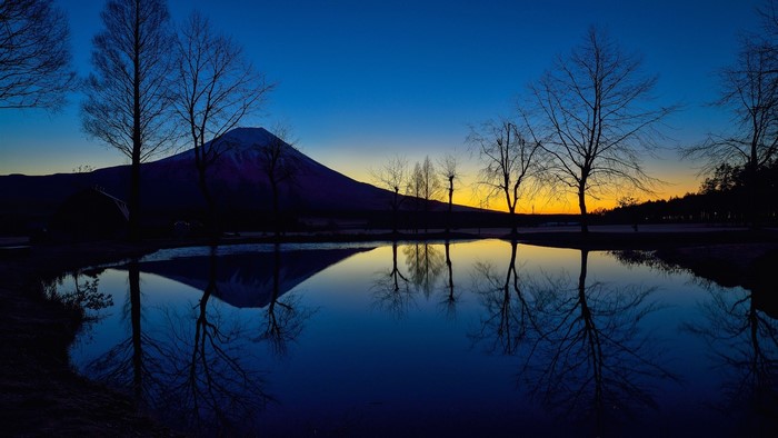Mount Fuji reflected in a lake at dusk