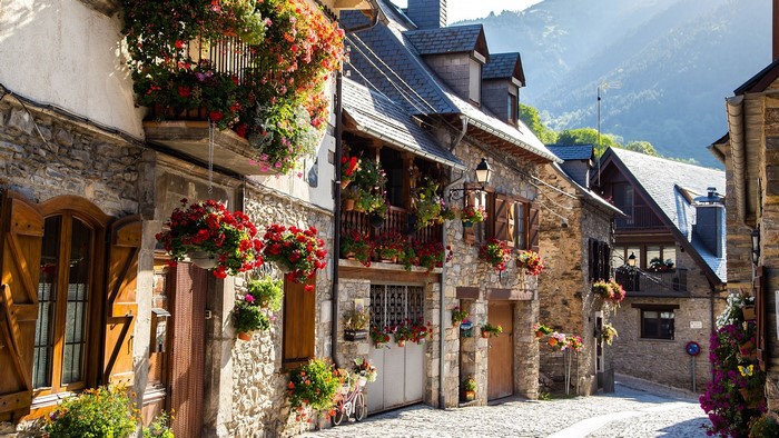 Idyllic Spanish town street with stone houses and flowers