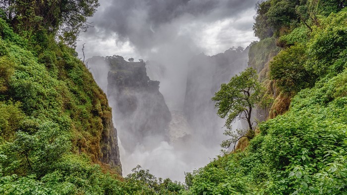 Victoria Falls in Zambia with lush green cliffs