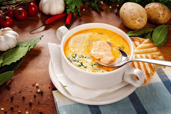 Creamy salmon soup with grilled bread and ingredients