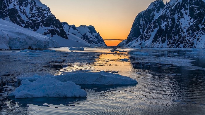 Sunrise over icy mountains and water in Antarctica