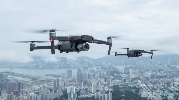 Two DJI Mavic 2 Pro drones flying over a city