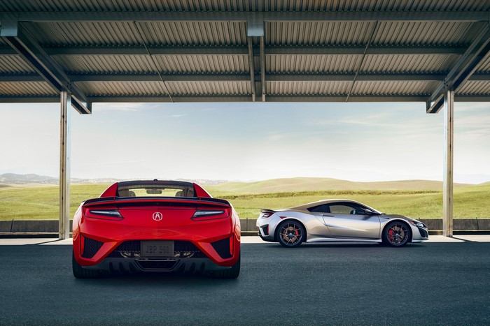 Red and silver Acura NSX cars parked under a canopy