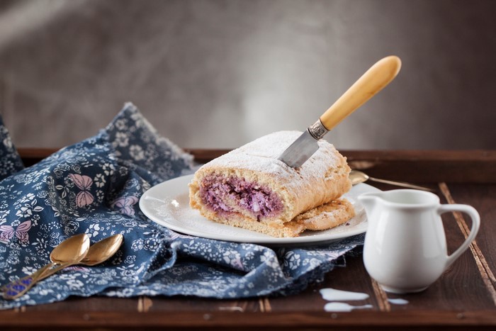 Dessert roll with purple filling on a plate