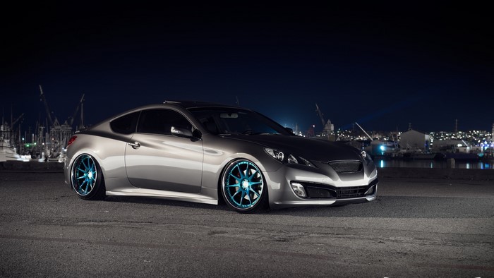 Silver Hyundai Genesis Coupe with blue wheels at night