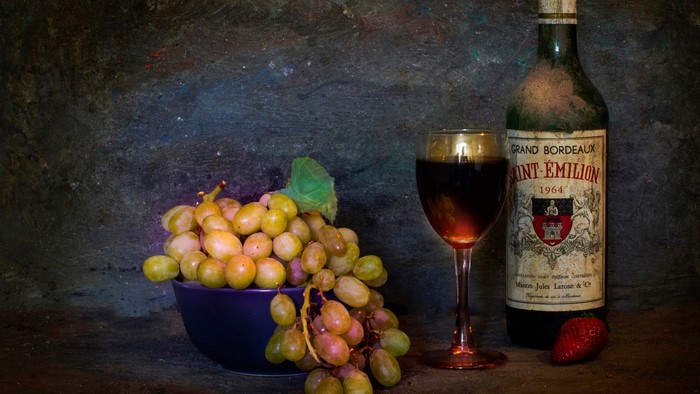Bottle of Saint-Émilion wine with grapes and strawberry