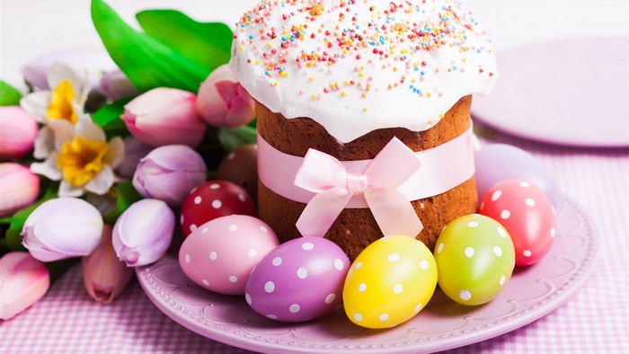 Easter cake with tulips and decorated eggs on a plate