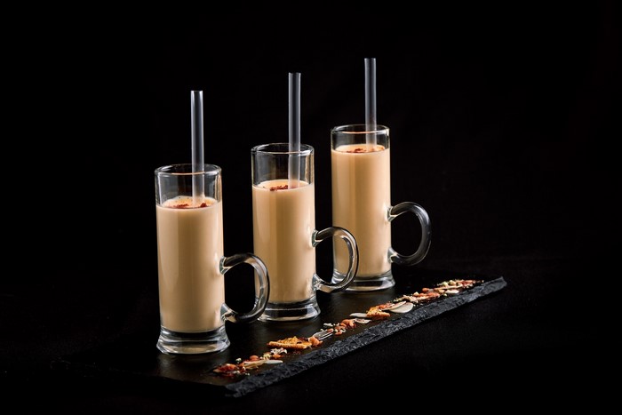 Three glasses of milk with straws and nuts