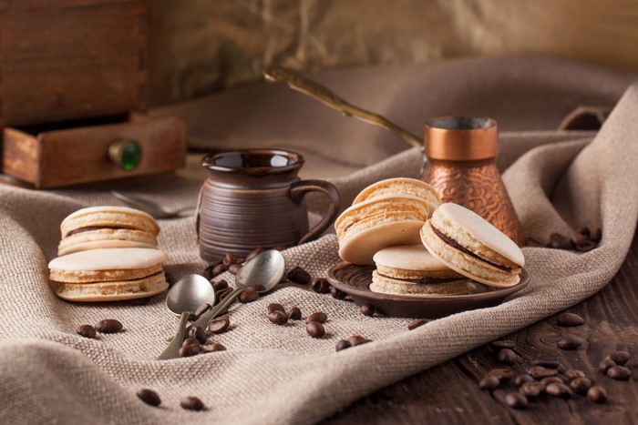 Macarons and coffee beans on a burlap cloth
