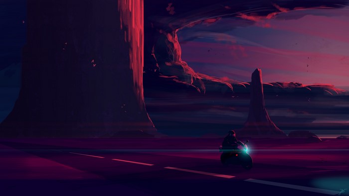 Motorcyclist on a desert highway at sunset